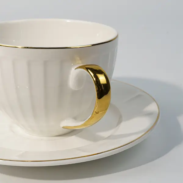 金色に塗られた取っ手が浮き彫りの陶器コーヒーマグ