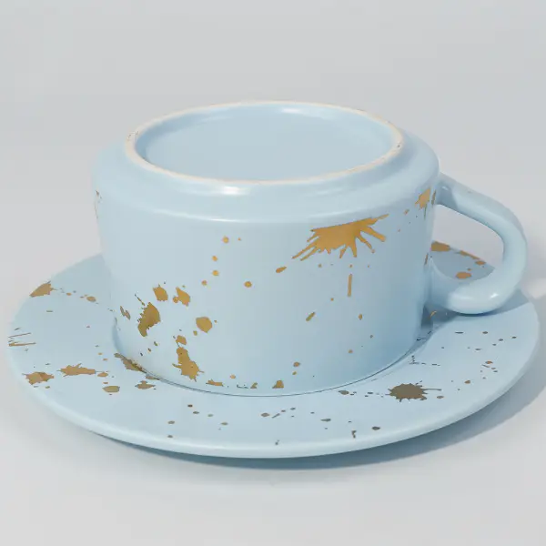 滑らかな釉薬仕上げを示す金箔陶器のコーヒーマグの下の写真