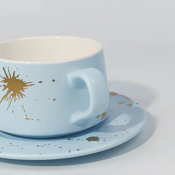 金箔の飛び散り装飾が施されたセラミックコーヒーマグの取っ手のディテール