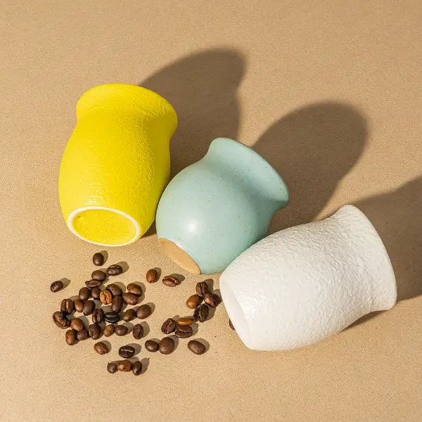 不規則な形のフロス加工された粗い陶器カップで、手作りの質感があります
